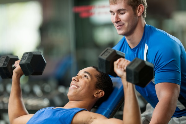 Jovem iniciando na musculação com acompanhamento profissional